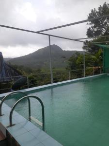 a swimming pool with a view of a mountain at Oasis villa in Vagamon