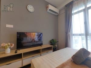 um quarto com uma cama, uma televisão e um relógio em K Avenue Modern Style Studio (5 Mins to Airport) em Kota Kinabalu