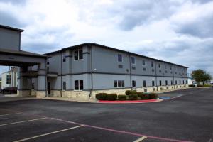 un gran edificio blanco con aparcamiento en Scottish Inns Killeen near Fort Cavazos, en Killeen