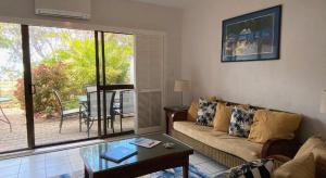 Beachfront Terraces with Onsite Reception & Check In في ميناء دوغلاس: غرفة معيشة مع أريكة وطاولة