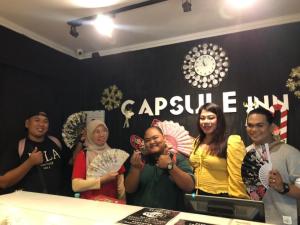 a group of people posing for a picture in a room at Capsule Inn in Kota Kinabalu