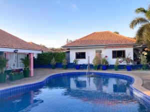 a swimming pool in front of a house at THAIGO Comfort Stay - Private House in Central Kanchanaburi in Kanchanaburi