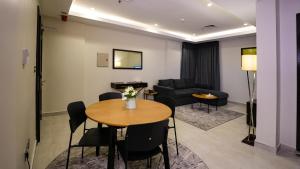 - un salon avec une table et un canapé dans l'établissement Saray Hotel Apartments, à Koweït