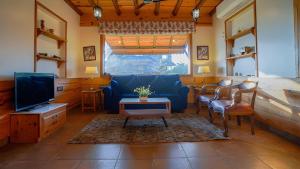 a living room with a blue couch and a tv at Hill Farm Stay in Pālampur