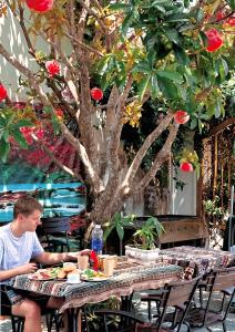 um homem sentado numa mesa em frente a uma árvore em Blue Fish Villa em Tân Thành (1)