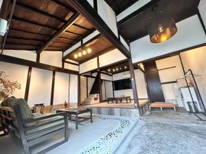 uma ampla sala de estar com uma banheira e uma televisão em 民泊SAKURA em Gose