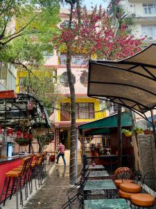 una calle con mesas y sillas y un árbol con flores rosas en Hotel Pala en Katmandú