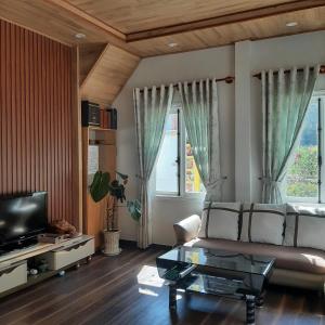 a living room with a couch and a tv at MIA Villa Đà Lạt in Khu Chi Lăng