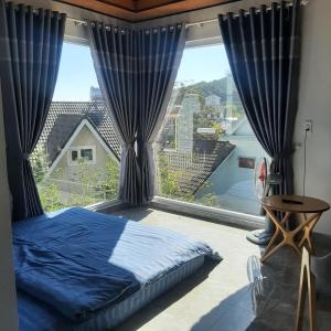 a bedroom with a bed and a large window at MIA Villa Đà Lạt in Khu Chi Lăng