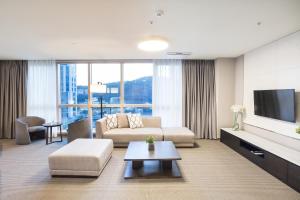 a living room with a couch and a tv at Centum Prime Hotel in Busan