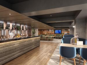 a man sitting at a table in a bar with a laptop at Novotel Nara in Nara