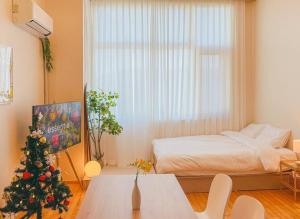 um quarto com uma árvore de Natal e uma cama em Seohyeon station 2min Sunny house with beautiful view #Cozy place #the place of the art collector em Seongnam