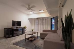 uma sala de estar com um sofá e uma televisão em 14pax 3br Walk to Sunway Pyramid Lagoon em Petaling Jaya