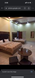 Cette chambre comprend 2 lits et une table. dans l'établissement Akash home stay, à Mussoorie