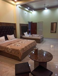 Cette chambre comprend 2 lits et une table. dans l'établissement Akash home stay, à Mussoorie
