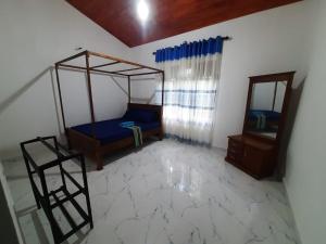 une chambre avec un lit à baldaquin et un miroir dans l'établissement Sundill Green Homestay, à Tangalle
