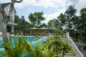 una piscina en un complejo con una casa en Villa The Legend Soc Son, en Hanói