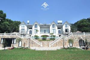 Casa grande con pared de piedra y escaleras en Villa The Legend Soc Son en Hanoi