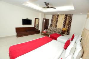 1 dormitorio con 1 cama grande con manta roja en Hotel Mars Meg at Delhi Airport, en Nueva Delhi