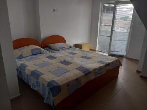 a bedroom with a bed with a blue and yellow quilt at Apartments Struska carsija in Struga