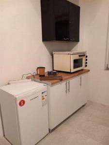 a kitchen with a microwave and a refrigerator at Apartments Struska carsija in Struga