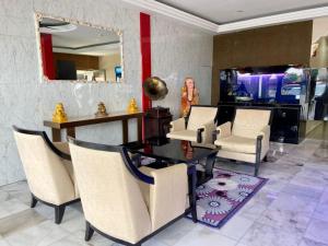 een kamer met stoelen, een tafel en een spiegel bij Royals Star Hotel in Seremban