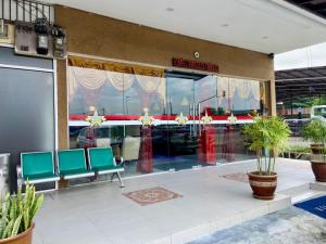 een lobby met groene stoelen en planten in een gebouw bij Royals Star Hotel in Seremban