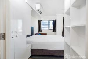 - une chambre blanche avec un lit et une fenêtre dans l'établissement Superior Studio 17 Endeavour, à Emu Park