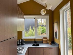 a kitchen with a sink and a window at Summ Lodge - luxe boutique lodge Veluwe in Nunspeet +45 photos