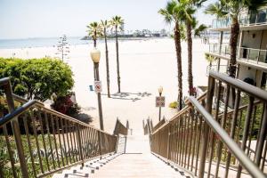 a stairway leading to the beach with palm trees at Seaside Bliss -Downtown! Beach! ConvCenter! Bikes! in Long Beach