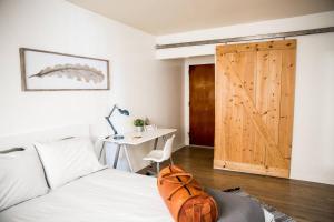 a bedroom with a bed and a desk and a wooden door at Seaside Bliss -Downtown! Beach! ConvCenter! Bikes! in Long Beach