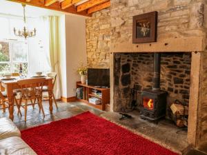 a living room with a stone fireplace and a table at Wayside Cottage in Consett