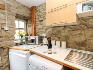 a kitchen with a counter top with wine glasses at Wayside Cottage in Consett