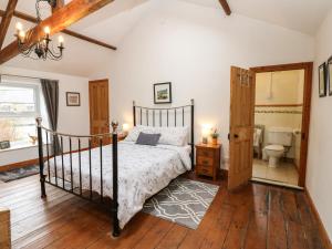 a bedroom with a bed and a bathroom with a toilet at Wayside Cottage in Consett