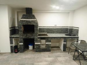 a stone fireplace in a room with a table and chairs at Casa Leahu in Baile Unu Mai +39 photos