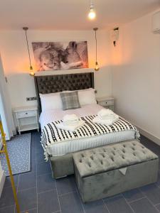 a bedroom with a large bed with a bench in it at Clarendon House - Hot Tub in Lincolnshire +1 photo