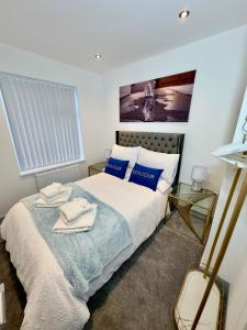 a bedroom with a bed with blue and white pillows at Clarendon House - Hot Tub in Lincolnshire