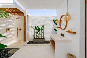 un baño con lavabo y espejo en Villa Emilia, en Tanah Lot