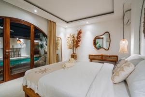 Un dormitorio con una cama blanca y un balcón. en Villa Emilia, en Tanah Lot