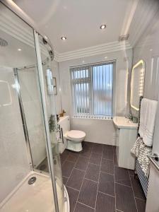 a bathroom with a shower and a toilet and a sink at Clarendon House - Hot Tub in Lincolnshire