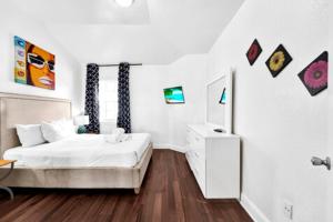 um quarto branco com uma cama e uma cómoda em Hispaniola Apartments Part of the Oasis Casita Collection em Miami Beach