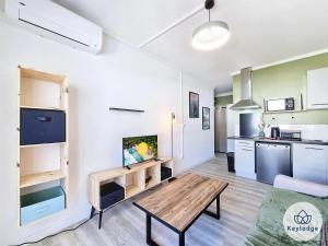 a living room with a table and a kitchen at Ti Studio Créole 2 - proche du centre ville - 21m² - Saint-Denis in Saint-Denis