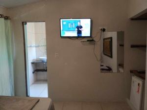 uma televisão numa parede num quarto em Pousada Tulum em Barra Grande