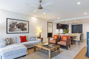 een woonkamer met een bank en een tafel bij Devine Rooftop Penthouse at Temple Resort in Port Douglas