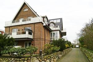 a large brick building with a balcony on top of it at WILDENTE-App-7 in Wenningstedt