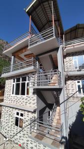 un edificio de ladrillo blanco con escaleras. en Wood packers en Kasol