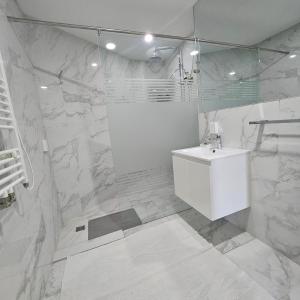 een witte badkamer met een wastafel en een douche bij Olympic Residence in Ulaanbaatar