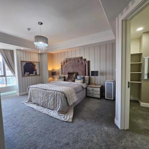 een grote slaapkamer met een groot bed en een kroonluchter bij Olympic Residence in Ulaanbaatar