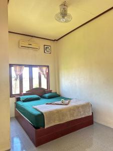 a bedroom with a bed in a room with a window at Happy bangalow Don det in Muang Không