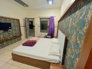a bedroom with a bed and a tv in it at Hotel JCM Chintpurni in Bharwain